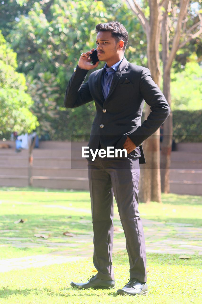 Man in formal suit , talking on phone