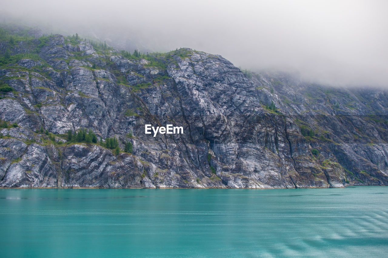 Scenic view of sea and mountains against sky