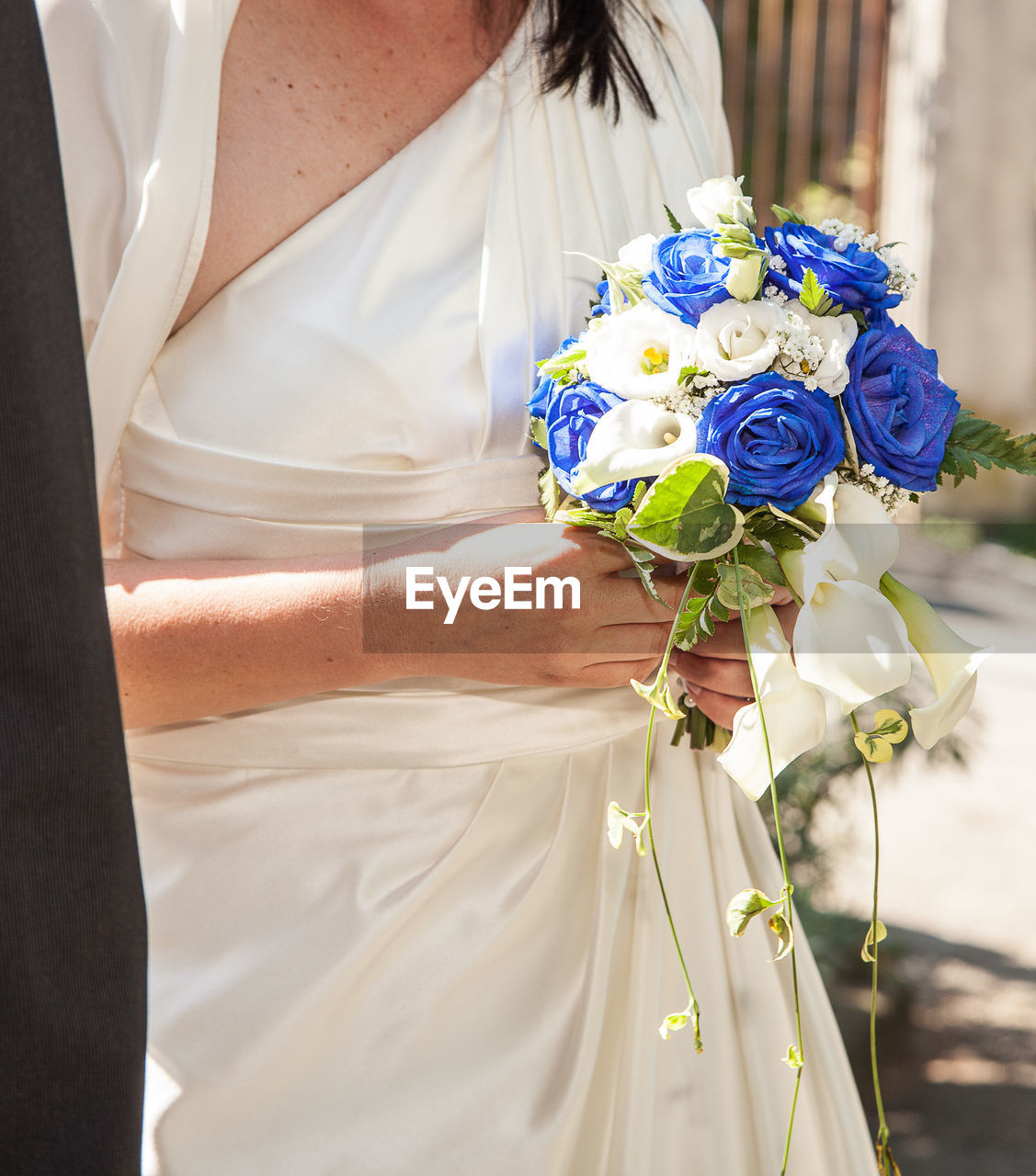 Midsection of bride holding flower bouquet during wedding