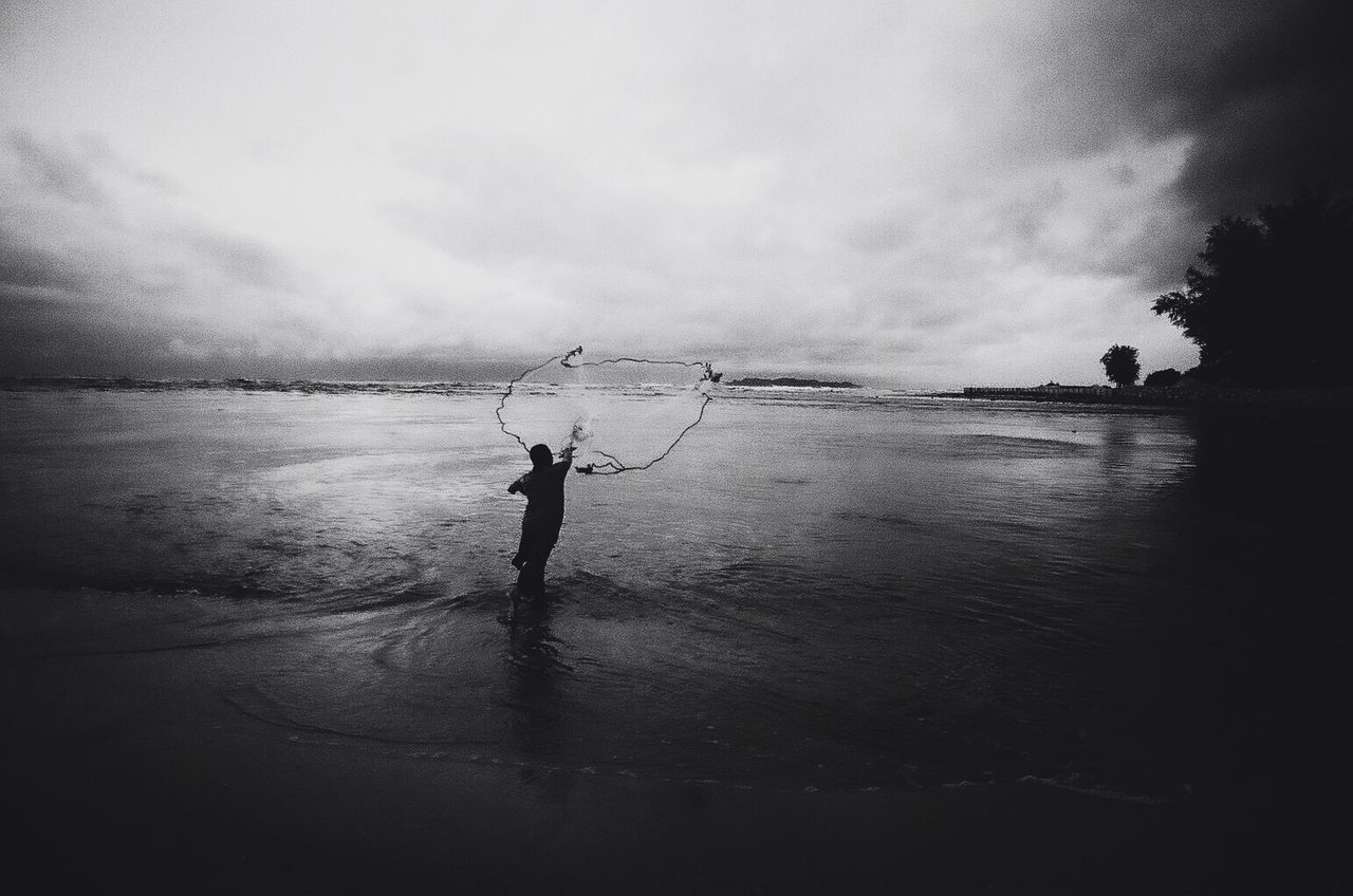 SILHOUETTE MAN FISHING IN SEA