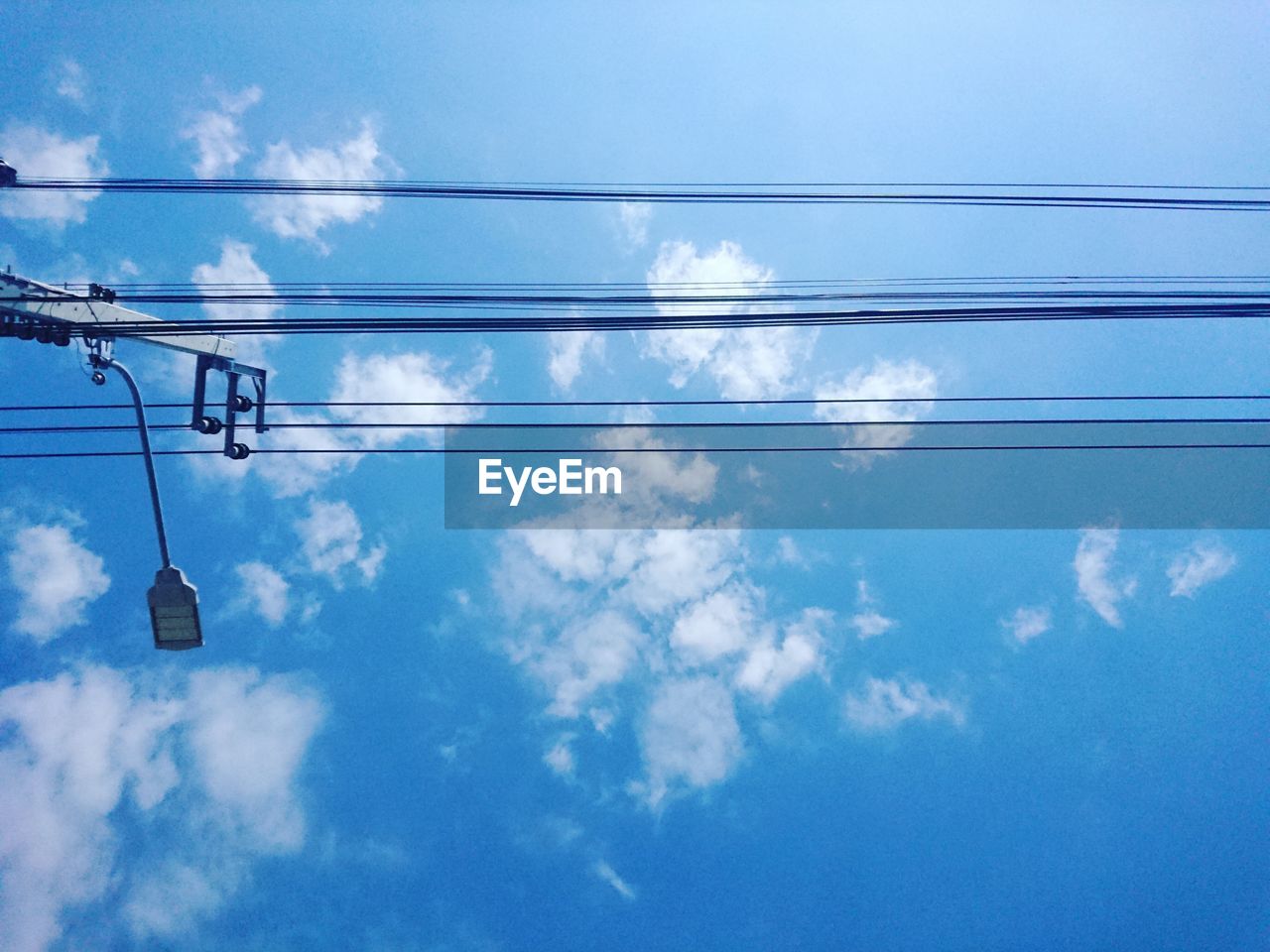 Low angle view of power cables against blue sky