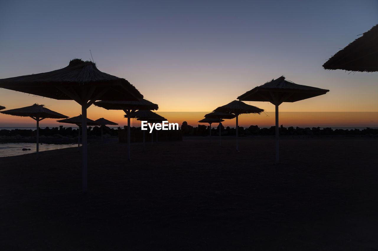 SILHOUETTE BEACH AGAINST CLEAR SKY DURING SUNSET