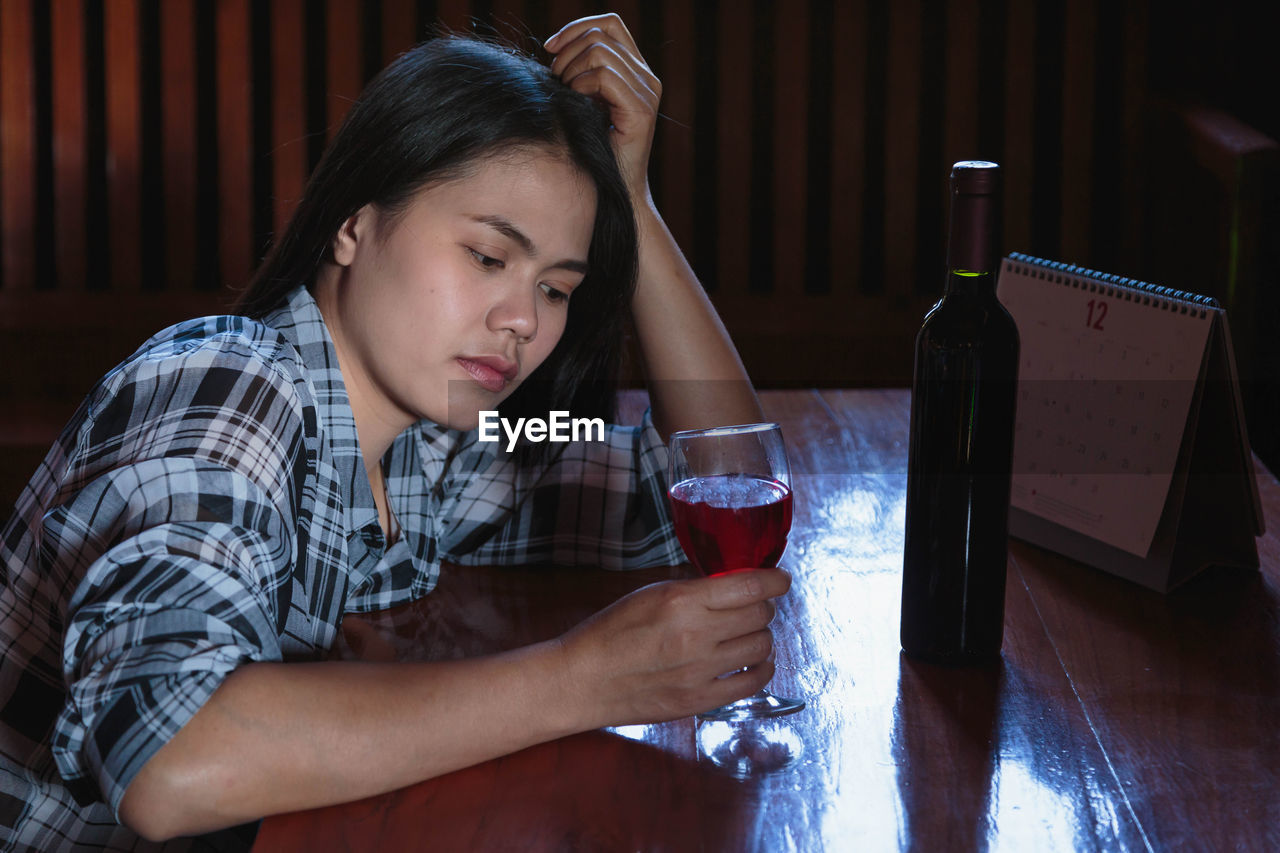 Mid adult man drinking glass on table