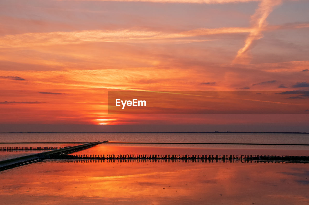 Scenic view of sea against romantic sky at sunset