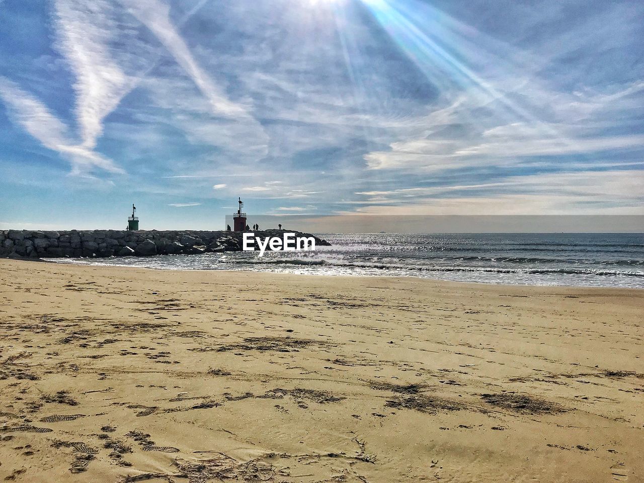 LIGHTHOUSE ON BEACH AGAINST SKY