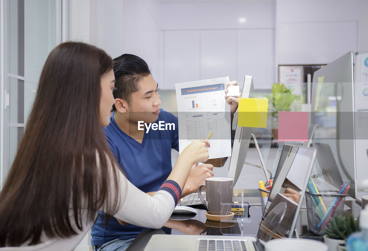 side view of young woman using smart phone while working at clinic