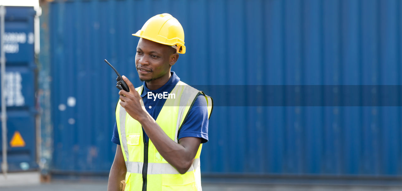 YOUNG MAN WORKING AGAINST CLEAR SKY