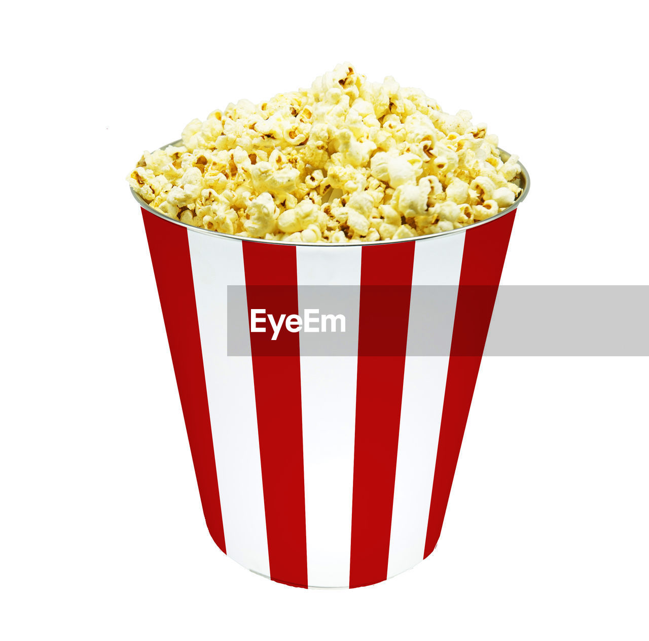 Side view popcorn in striped bucket isolated on white background.