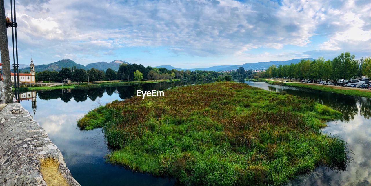 Scenic view of lake by mountains against sky