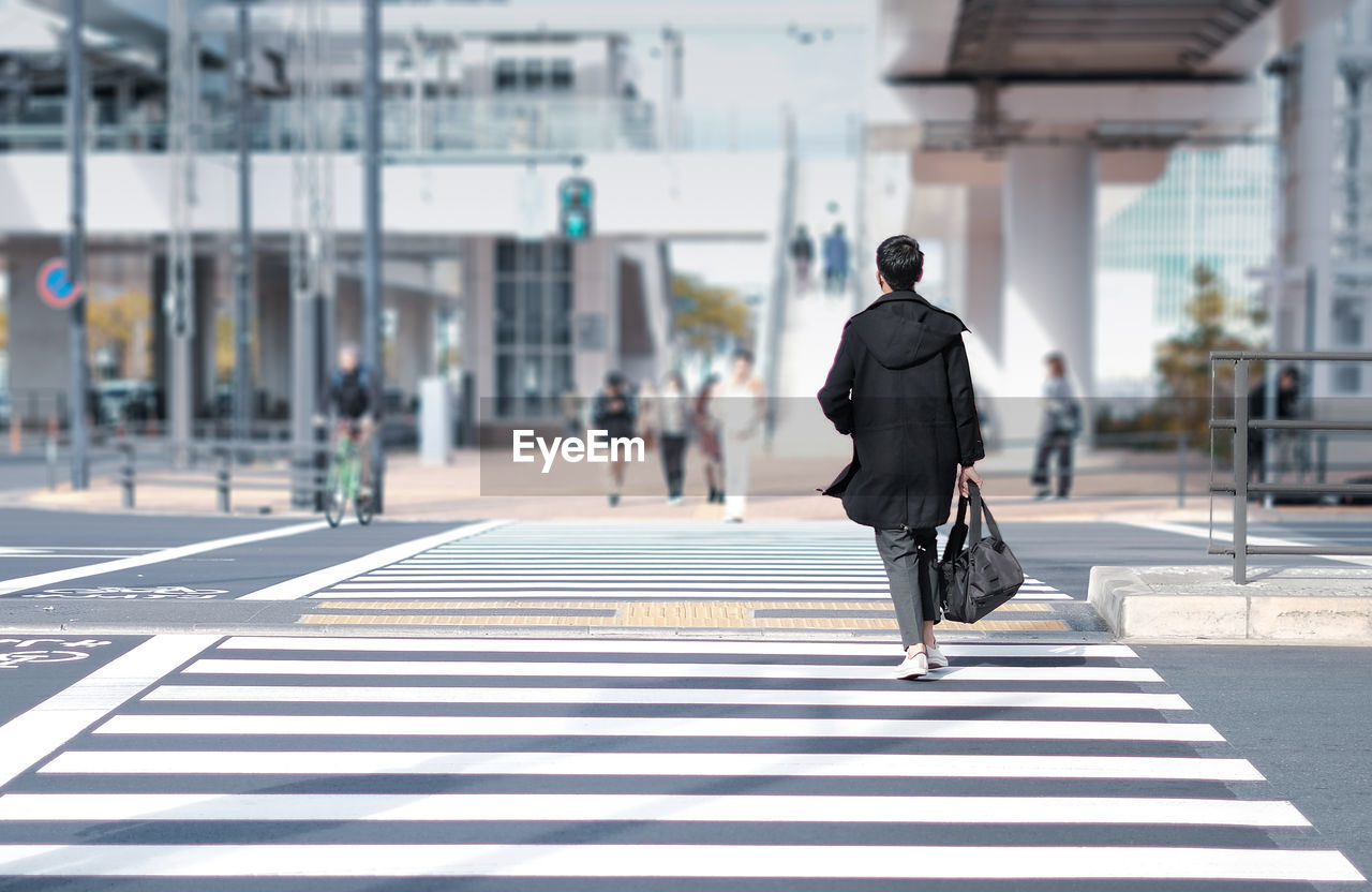 Rear view of man walking on road