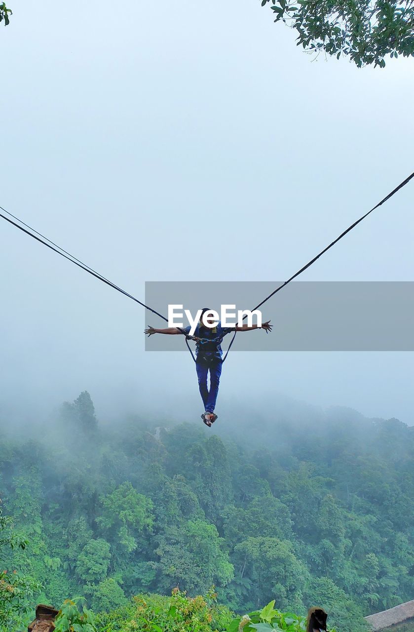 A man swing in the sky by rope