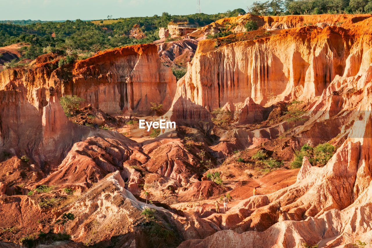 Tourists dwarfed by the rock formations at marafa depression - hell's kitchen at sunset in kenya