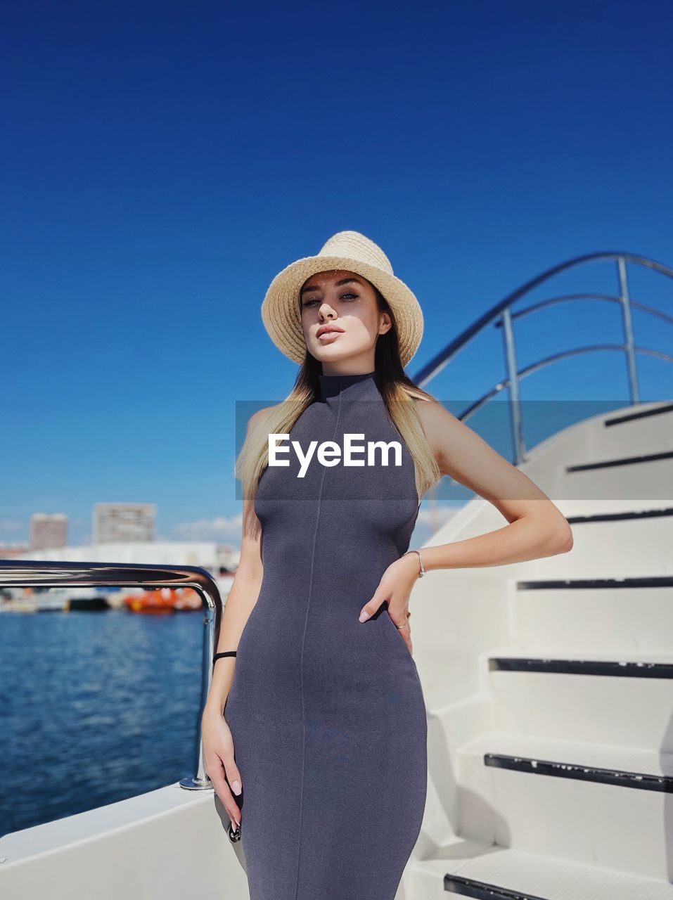 Portrait of young woman standing against sea