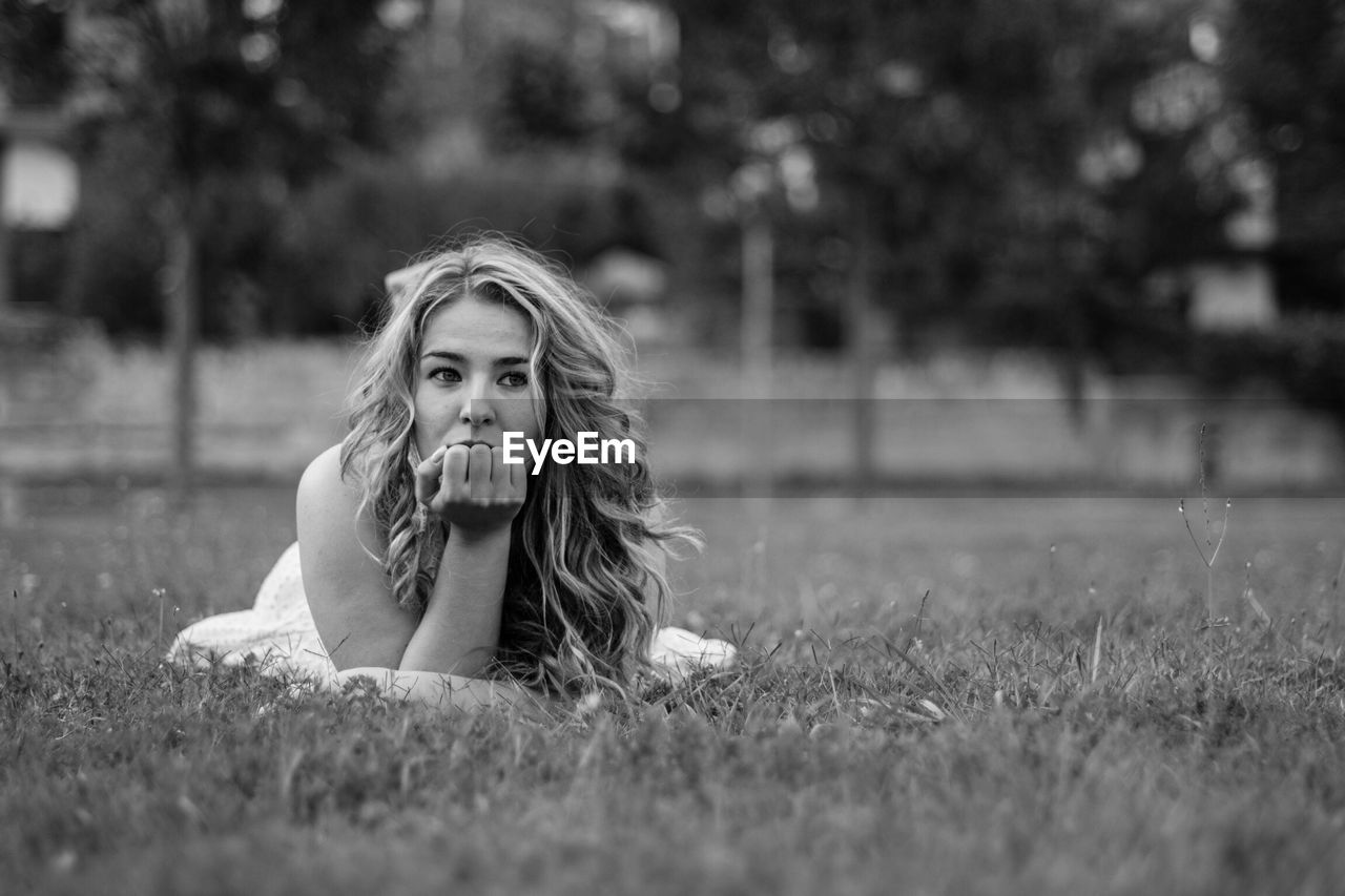 Young woman lying on grassy field