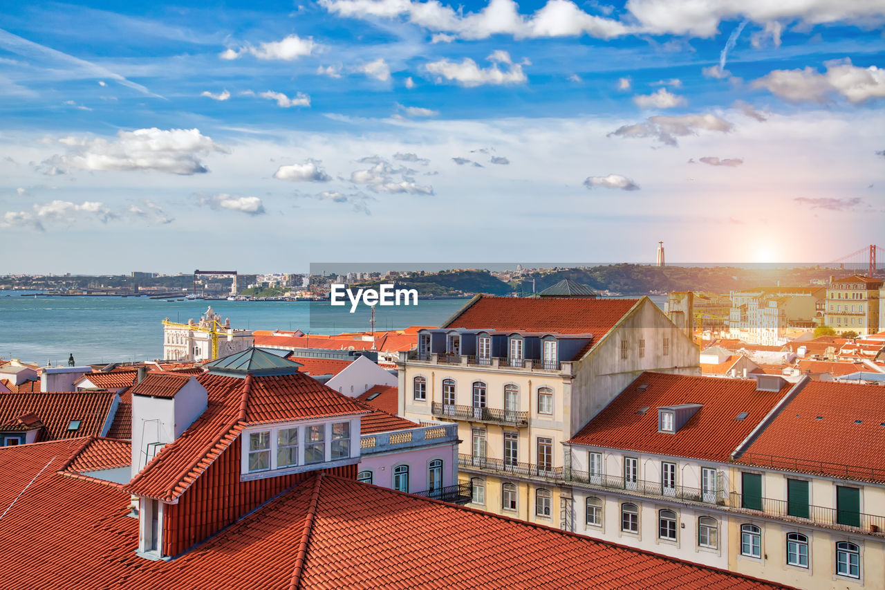 Houses by sea against sky in town