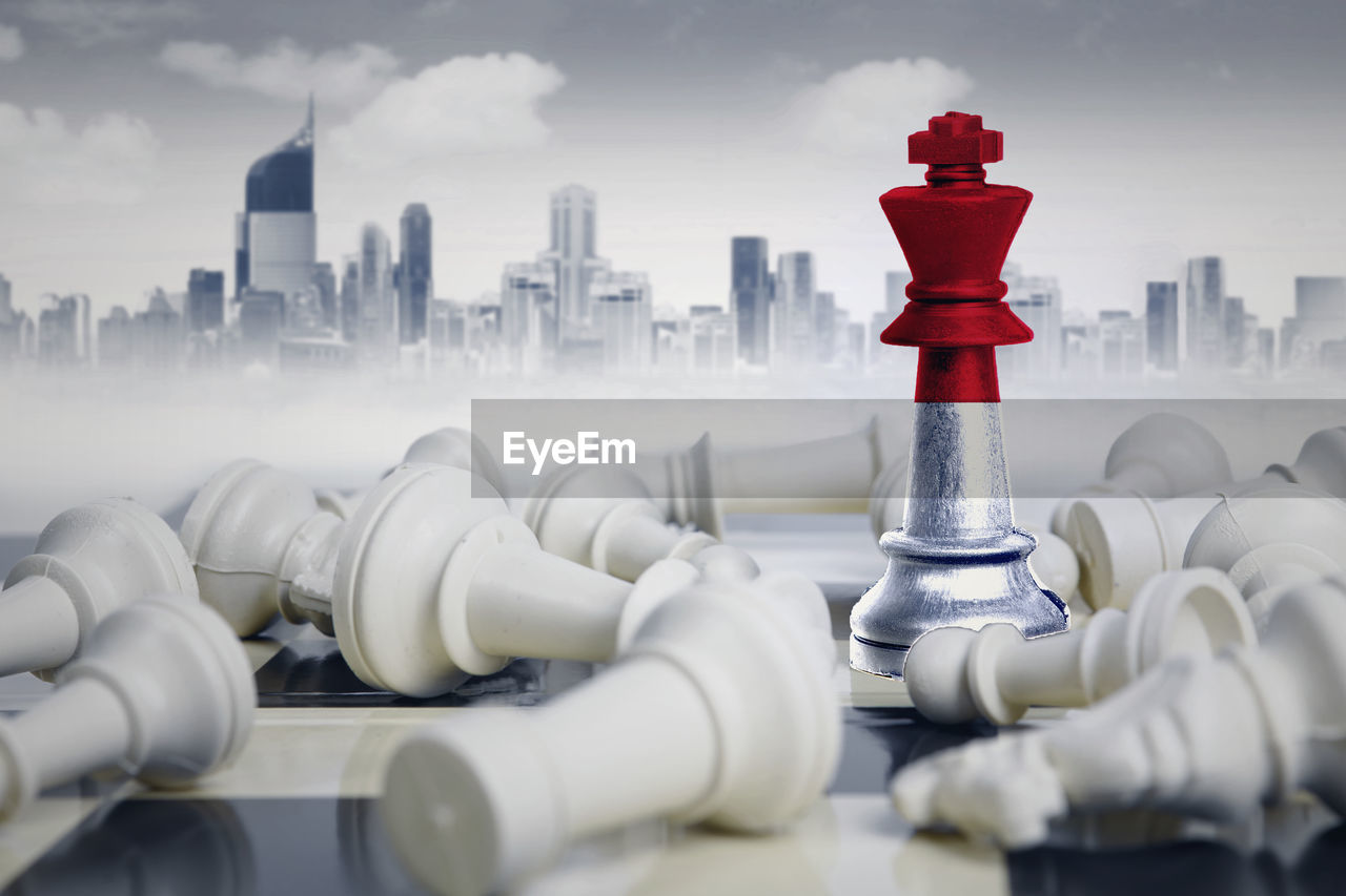 Digital composite image of chess pieces with flag against buildings in city