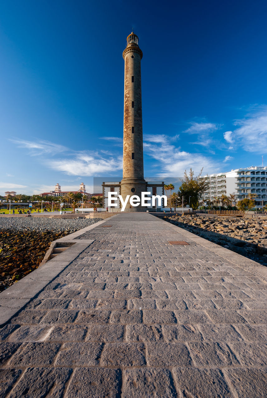 ROAD BY BUILDINGS AGAINST SKY