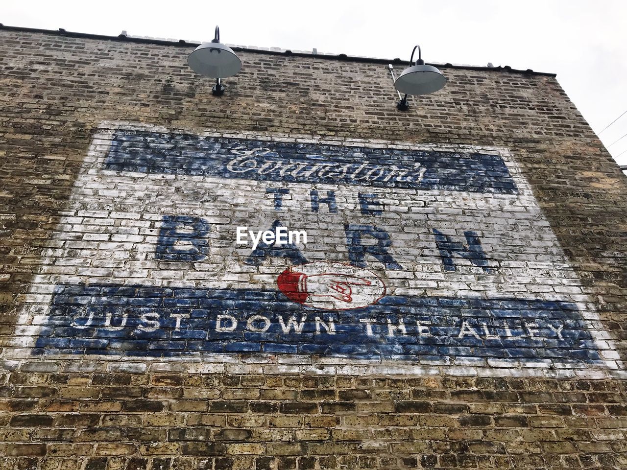 LOW ANGLE VIEW OF TEXT WRITTEN ON BRICK WALL