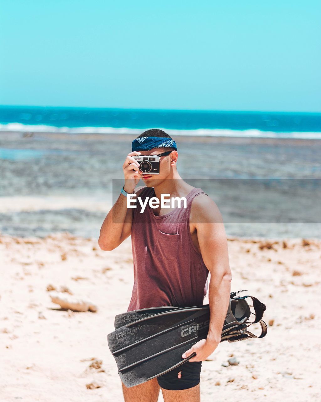 WOMAN WEARING SUNGLASSES STANDING ON BEACH