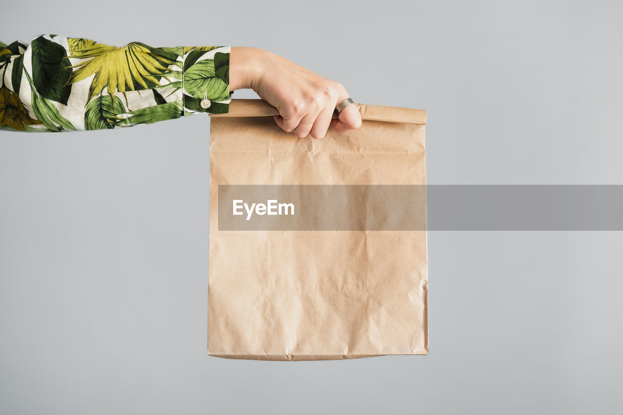 Midsection of man holding paper against white background