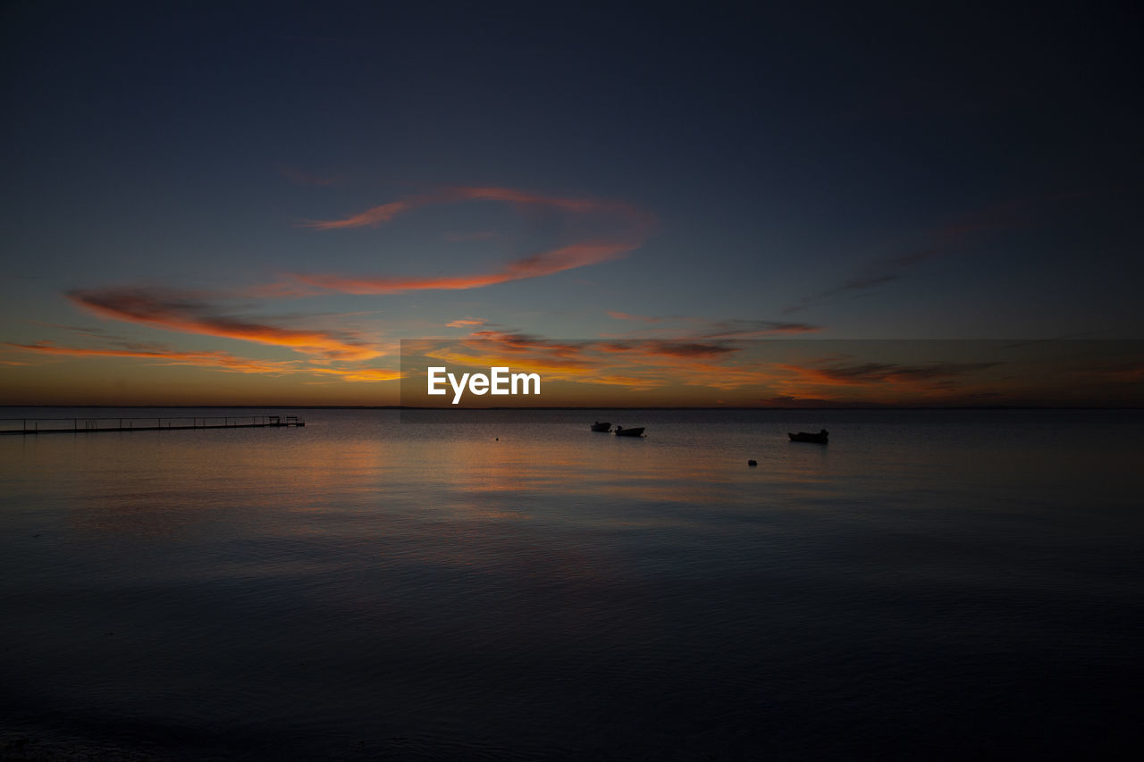 Scenic view of sea against romantic sky at sunset
