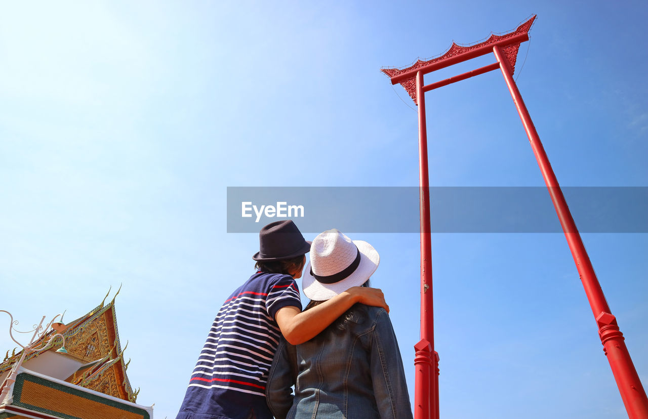 Couple looking up to the amazing giant swing or sao ching cha, in old city of bangkok, thailand