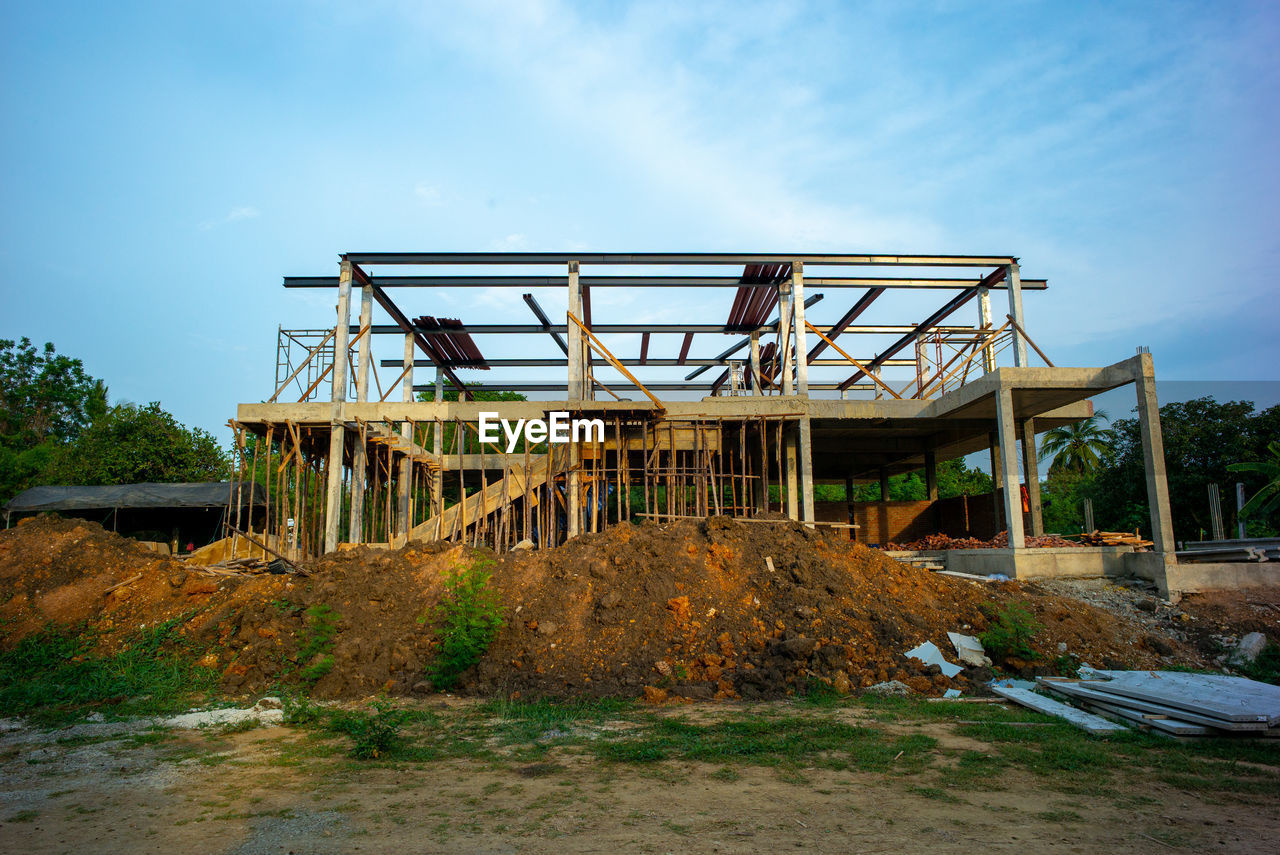 Perspective of house structure under construction at site with blue sky background