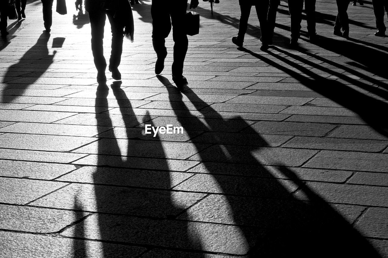 Shadow of people walking on footpath