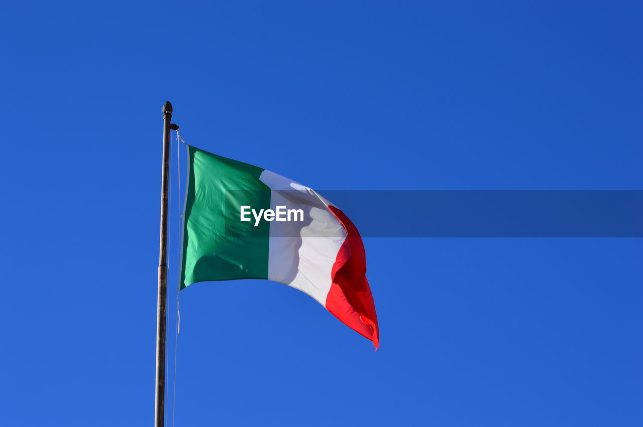 Low angle view of italian flag against clear blue sky