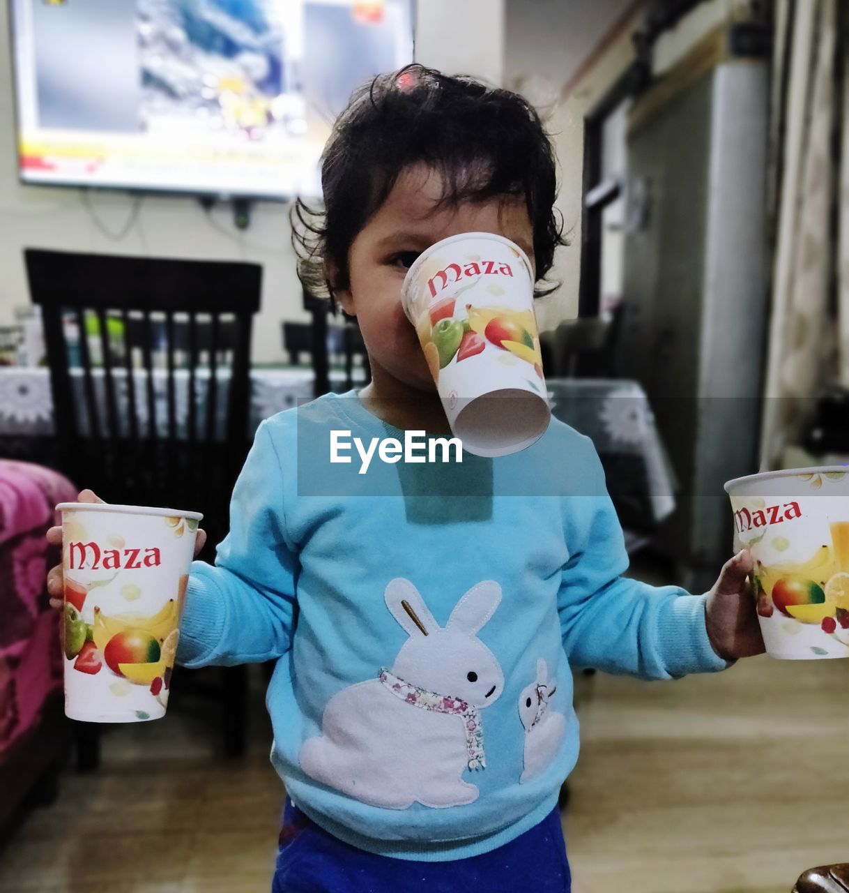 FULL LENGTH OF A GIRL HOLDING ICE CREAM IN CUP