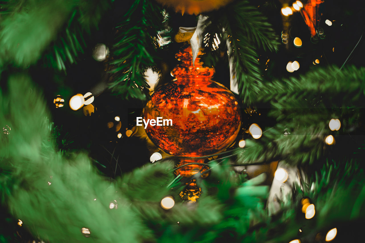 Close-up of illuminated christmas tree with hanging ornaments