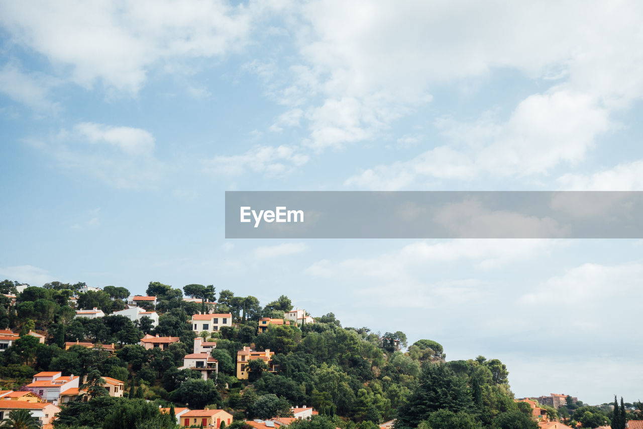 architecture, sky, cloud, tree, building exterior, built structure, building, nature, plant, city, residential district, horizon, hill, house, outdoors, day, no people, environment, cityscape, copy space, landscape, rural area, travel destinations, land, beauty in nature, town, travel, scenics - nature, high angle view