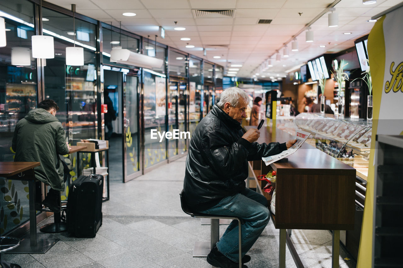 FULL LENGTH OF MAN SITTING ON STORE