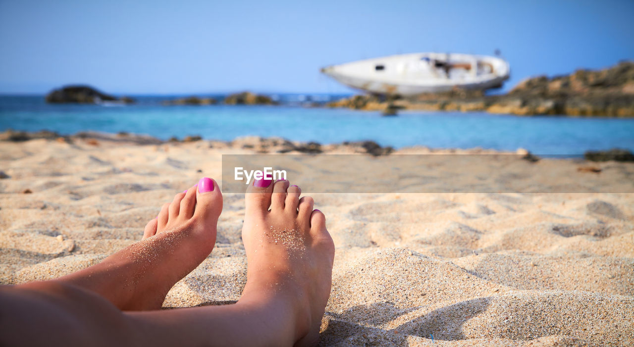 Low section of woman relaxing on beach