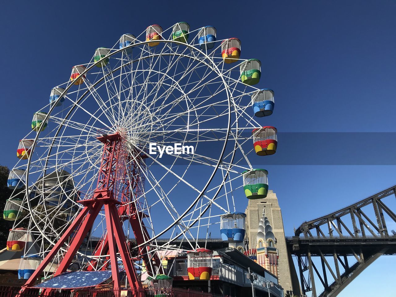 LOW ANGLE VIEW OF FERRIS WHEEL AGAINST CLEAR BLUE SKY