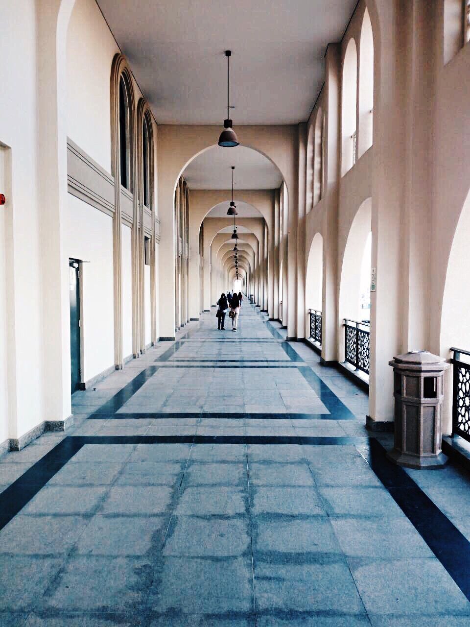 MAN WALKING IN CORRIDOR OF BUILDING