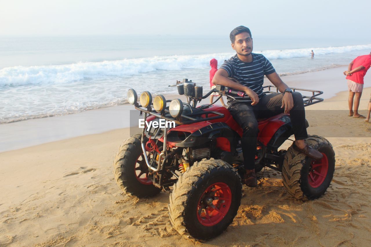 Portrait of man riding motorcycle on beach