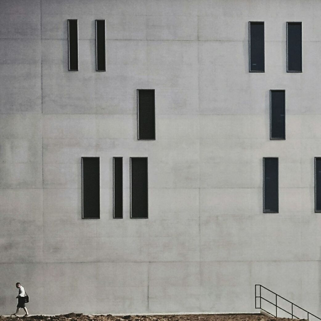 Man walking against building