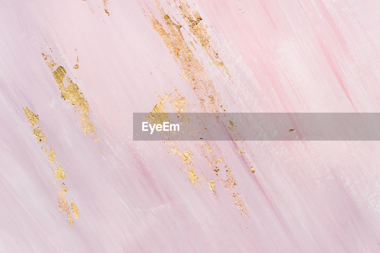 Delicate pink marble background with gold brushstrokes. place for your design.