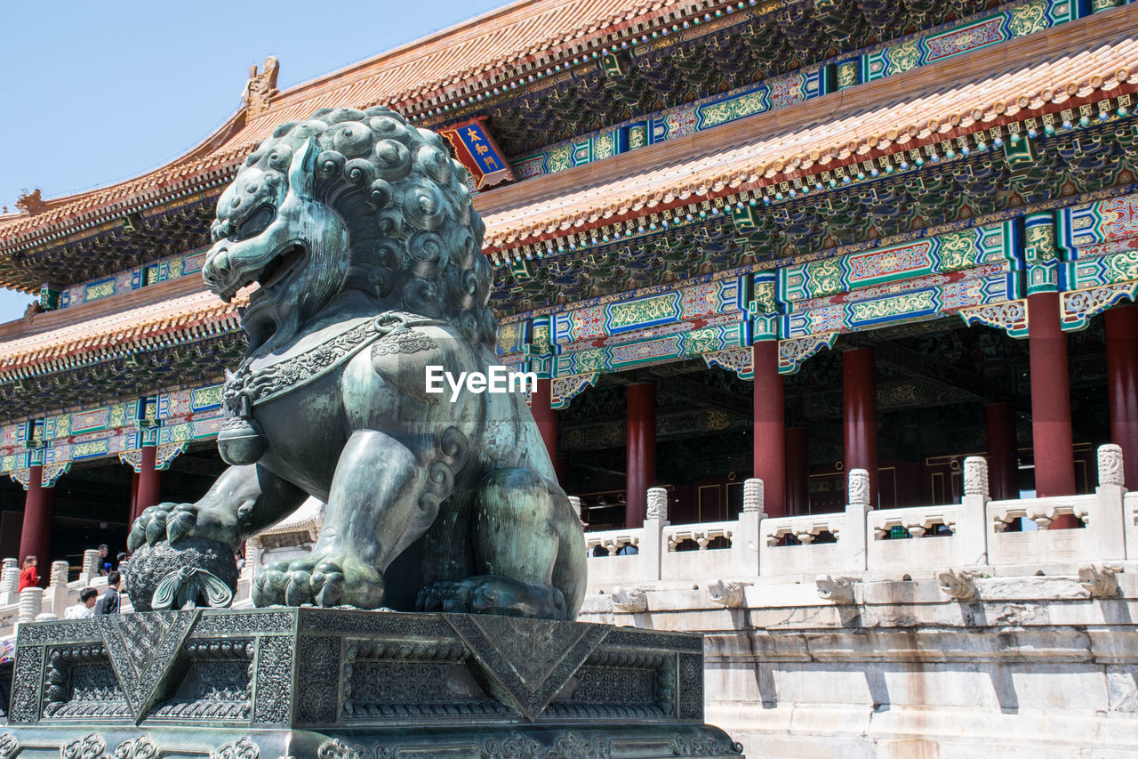 Lion statue against temple in city