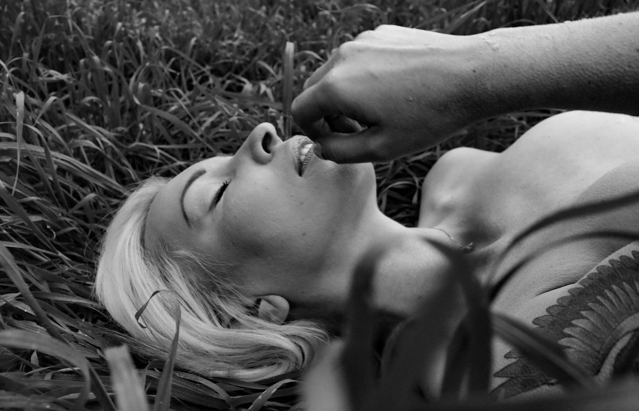 Close-up of young woman lying on grass