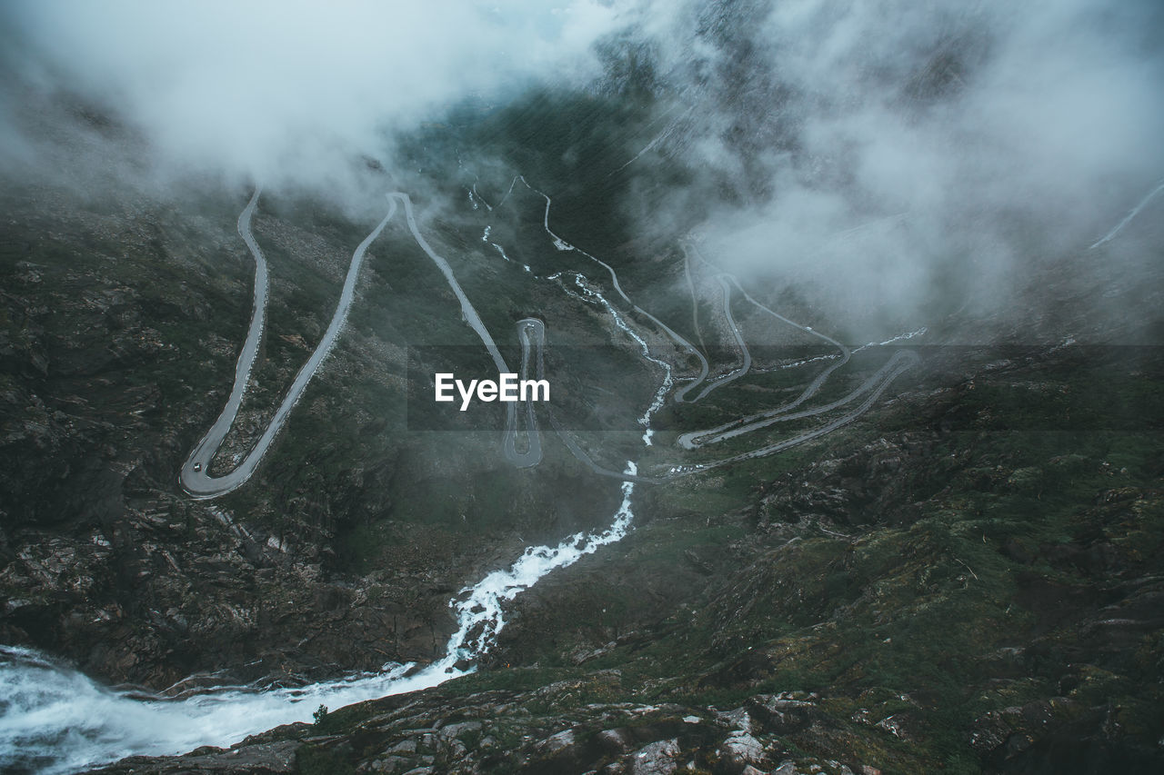 Scenic view of waterfall and winding mountain road 