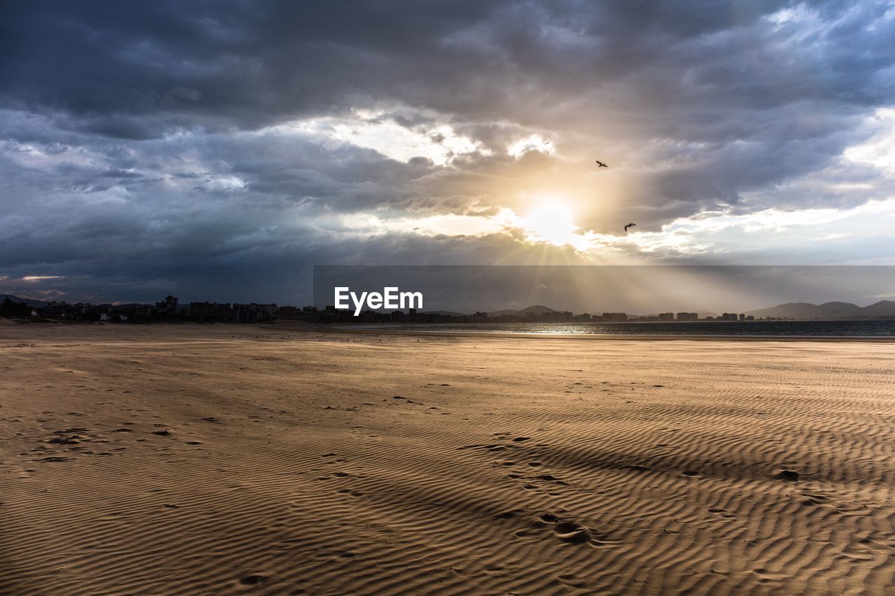 SCENIC VIEW OF LANDSCAPE AGAINST CLOUDY SKY AT SUNSET