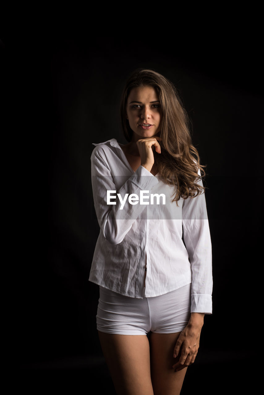 PORTRAIT OF A BEAUTIFUL YOUNG WOMAN OVER BLACK BACKGROUND