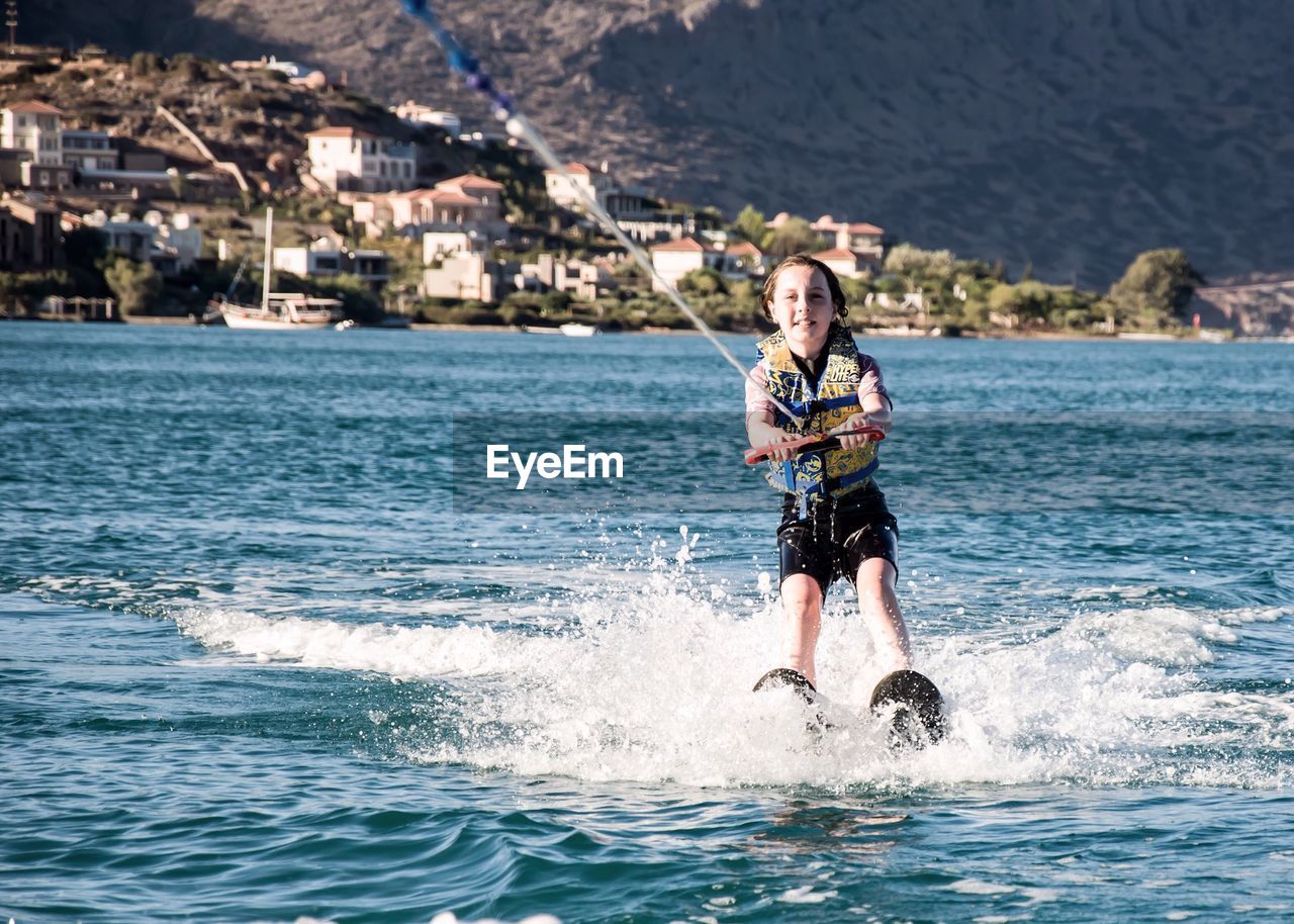 Full length of boy wakeboarding in sea