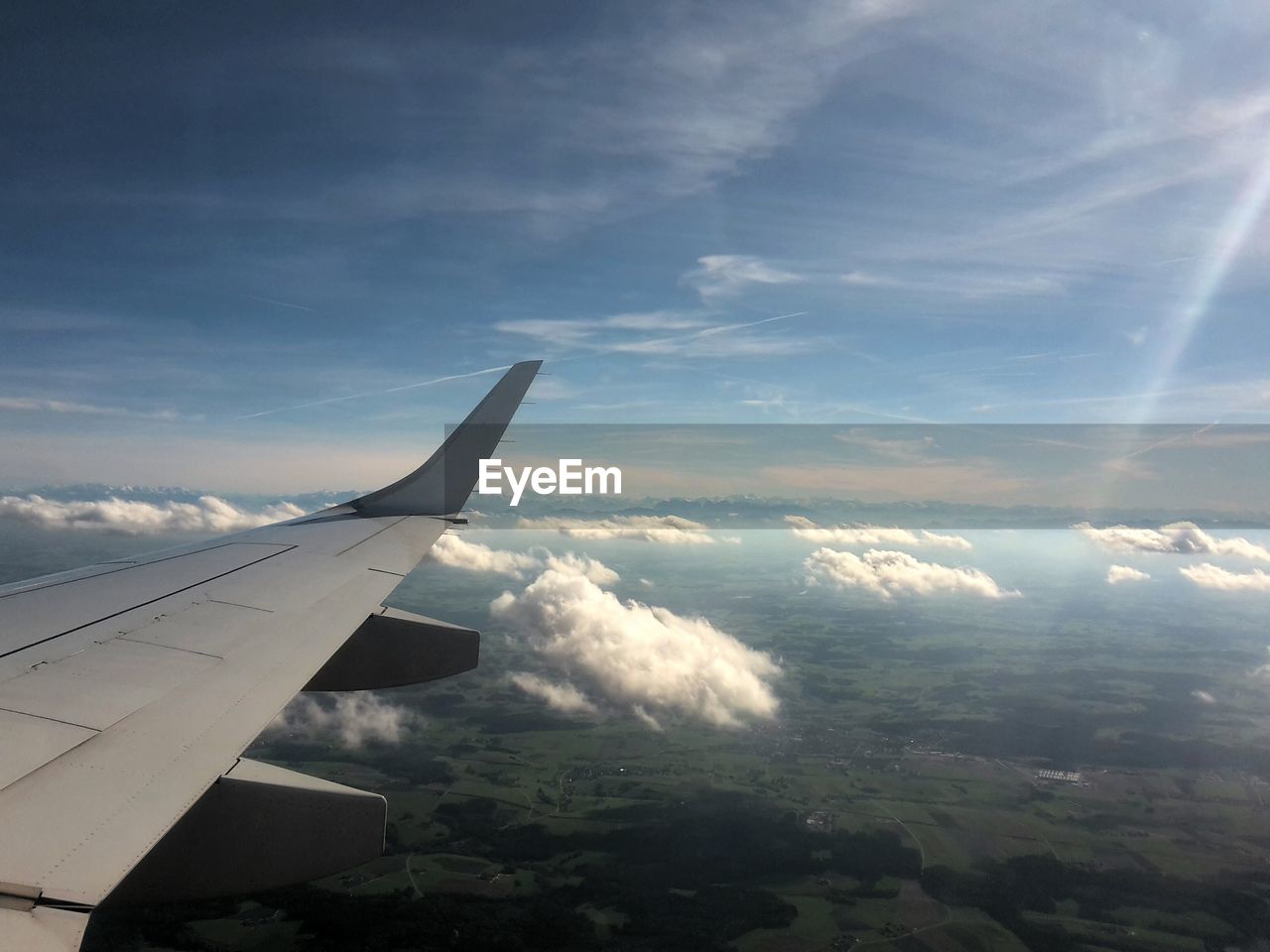 Aerial view of airplane wing over clouds