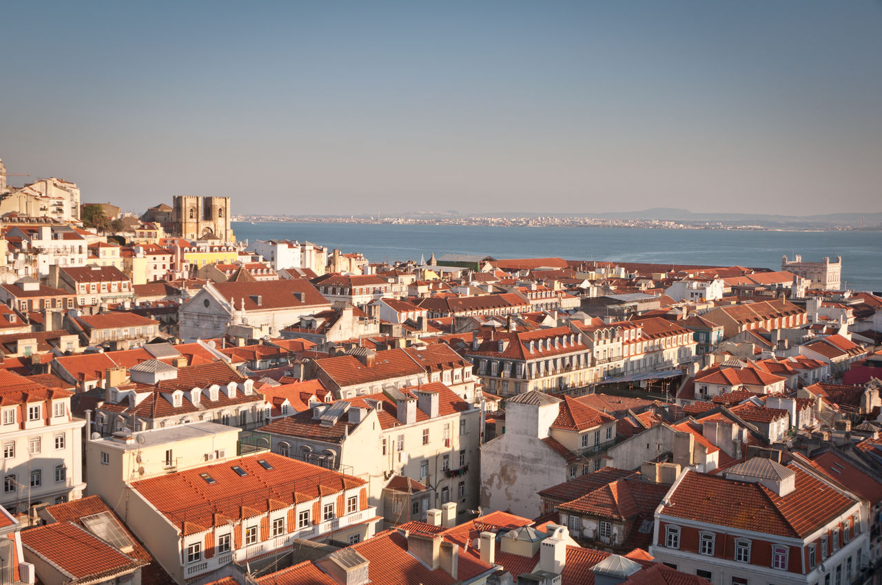 High angle view of townscape by sea against clear sky