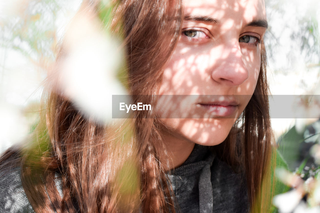 Close-up portrait of teenage girl during sunny day