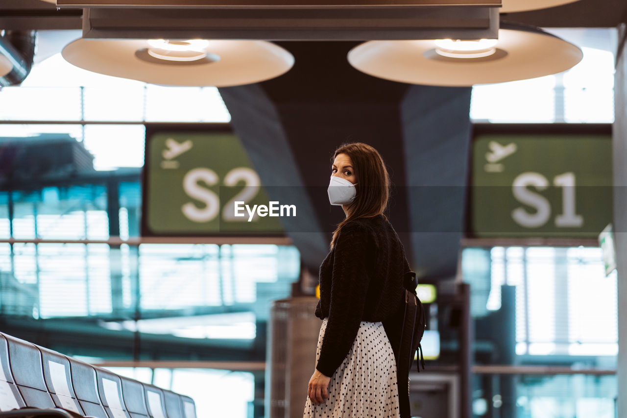 Portrait of smiling woman wearing mask at airport