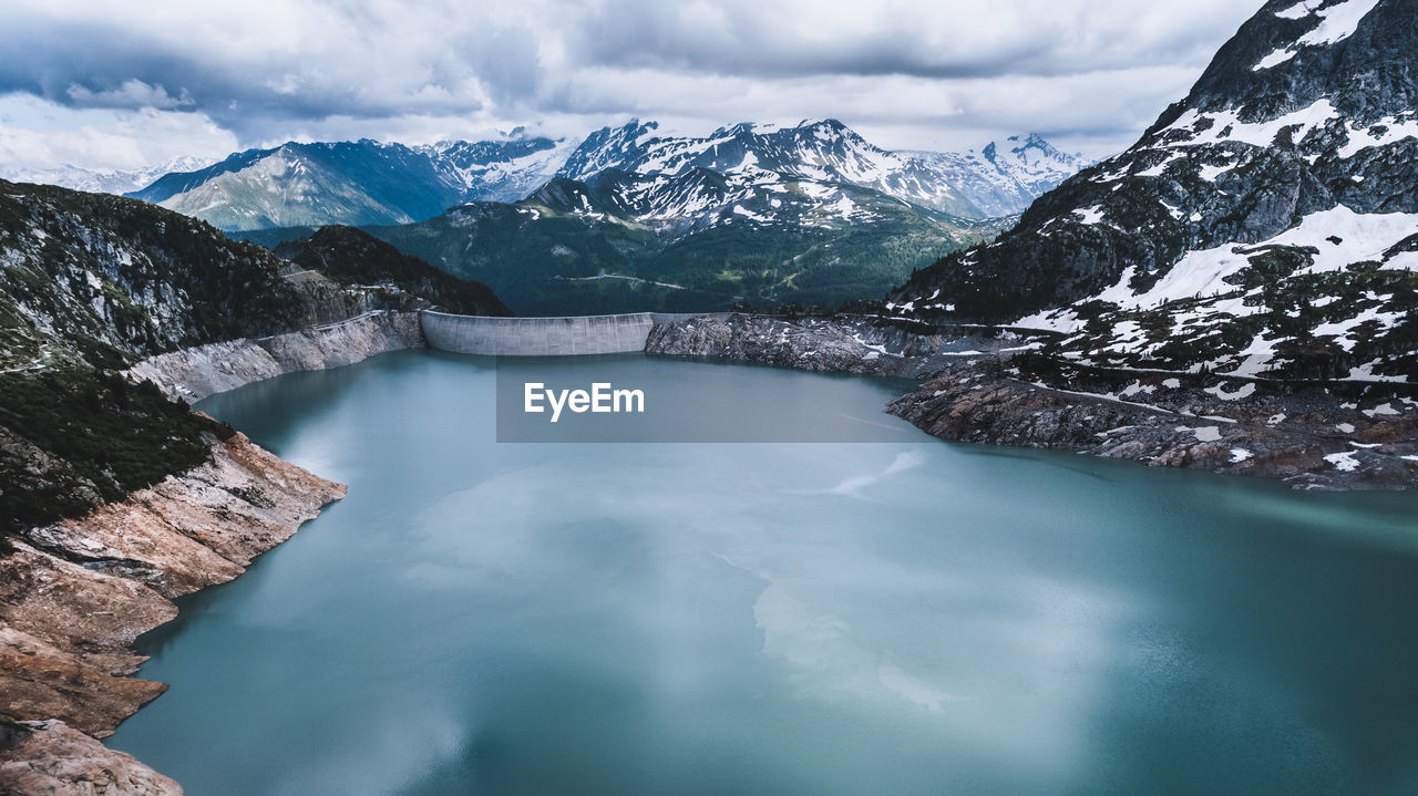 Scenic view of lake and snowcapped mountains against sky